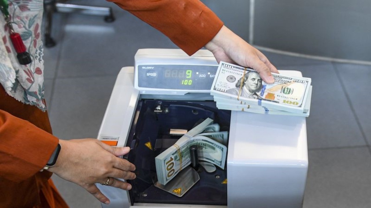 Petugas menghitung uang pecahan dolar AS di gerai penukaran mata uang asing VIP (Valuta Inti Prima) Money Changer, Jakarta, Senin (20/11/2023). ANTARA FOTO/Muhammad Adimaja/YU