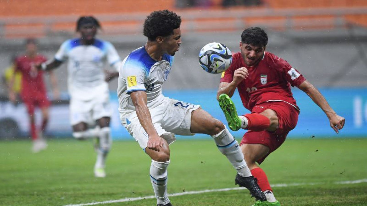 Pesepak bola Timnas Inggris Ethan Nwaneri (kiri) berebut bola dengan pesepak bola Timnas Iran Abolfazl Zoleikhaei (kanan) dalam penyisihan Grup C Piala Dunia U-17 2023 di Jakarta International Stadium, Jakarta, Selasa (14/11/2023). ANTARA FOTO/Sigid Kurniawan/app/tom