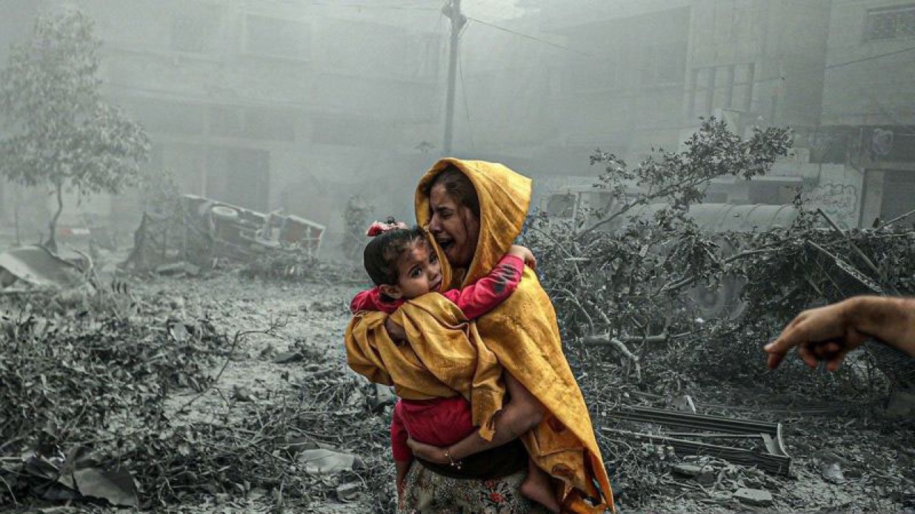 Seorang wanita menggendong seorang gadis bereaksi setelah serangan udara Israel menghantam lingkungan Ridwan di Kota Gaza, Gaza pada 23 Oktober 2023. (ANTARA/Ali Jadallah/Anadolu/pri.)