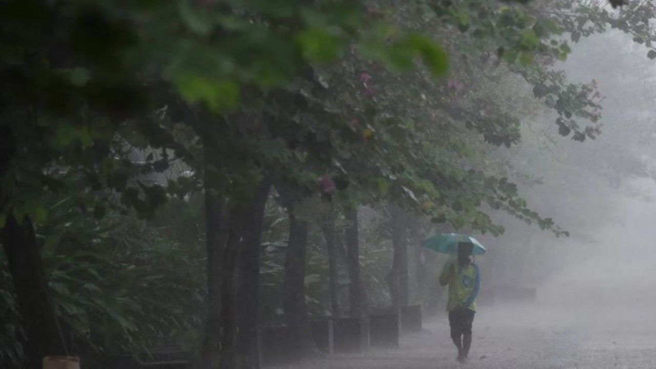 Warga menggunakan payung menembus hujan lebat. ANTARA FOTO/Wahyu Putro A/foc/pri.
