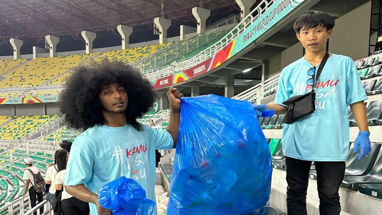 Salah seorang pegiat lingkungan hidup Ikram Afro (kiri) menunjukkan sampah yang telah terkumpul di area Stadion GBT Surabaya, Jumat (10/11/2023) malam. (ANTARA/HO-LOC WCU17)