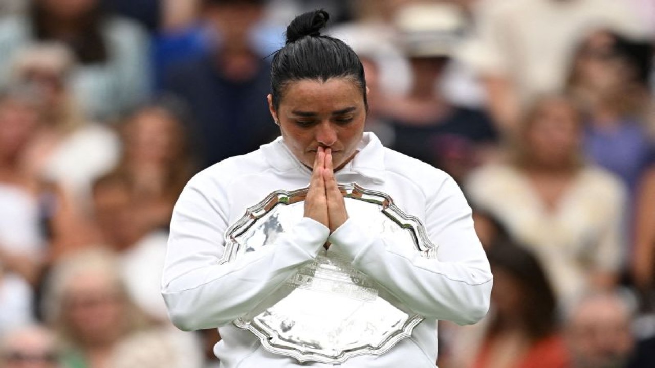 Petenis Tunisia Ons Jabeur memegang trofi runner up setelah kalah dalam pertandingan final Wimbledon melawan petenis Ceko Marketa Vondrousova di All England Lawn Tennis and Croquet Club, London, Inggris, Sabtu (15/7/2023). (ANTARA/REUTERS/Dylan Martinez)