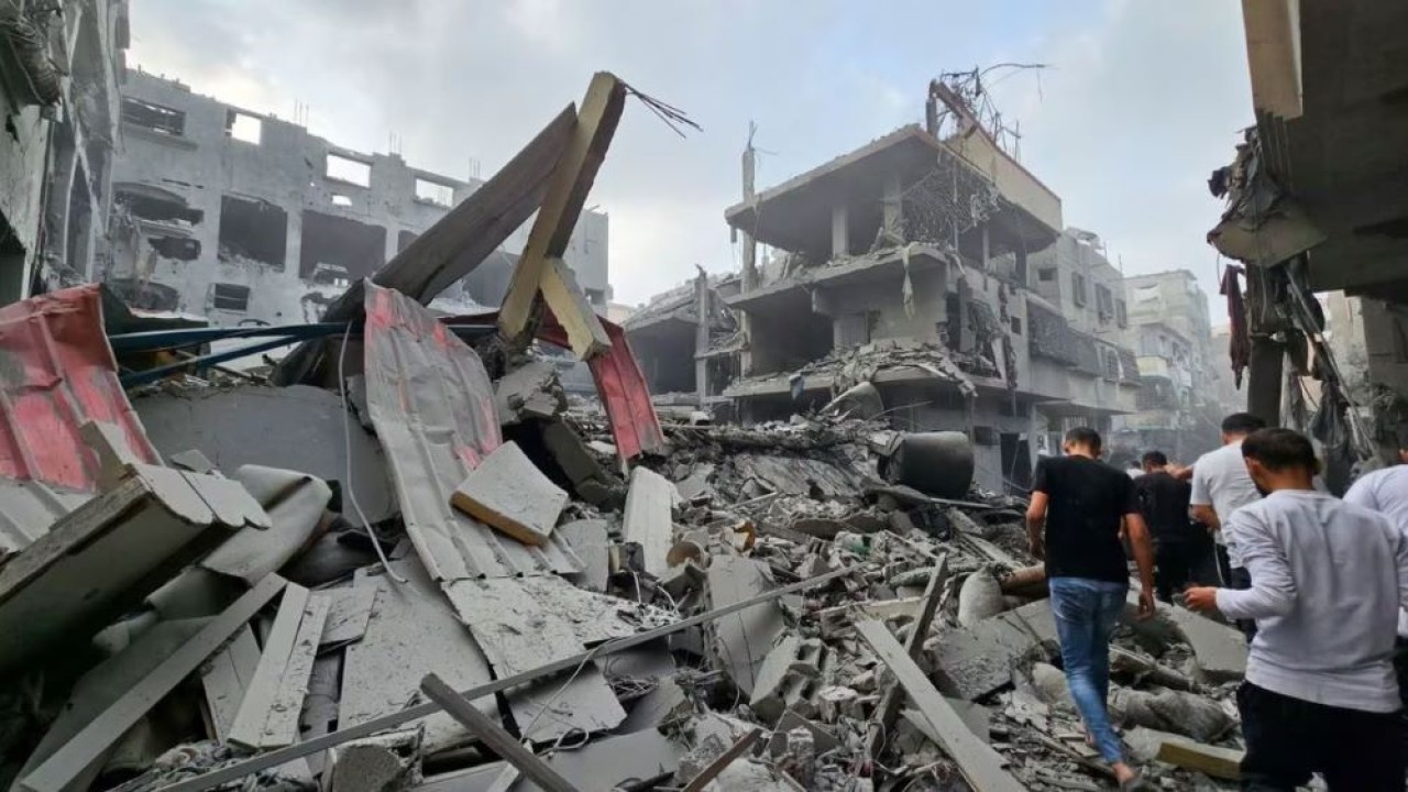 Warga Palestina berkumpul di lokasi serangan Israel terhadap rumah-rumah, saat konflik antara Israel dan kelompok militan Palestina Hamas berlanjut, di Jalur Gaza utara 23 Oktober 2023. (Anas al-Shareef/Reuters)