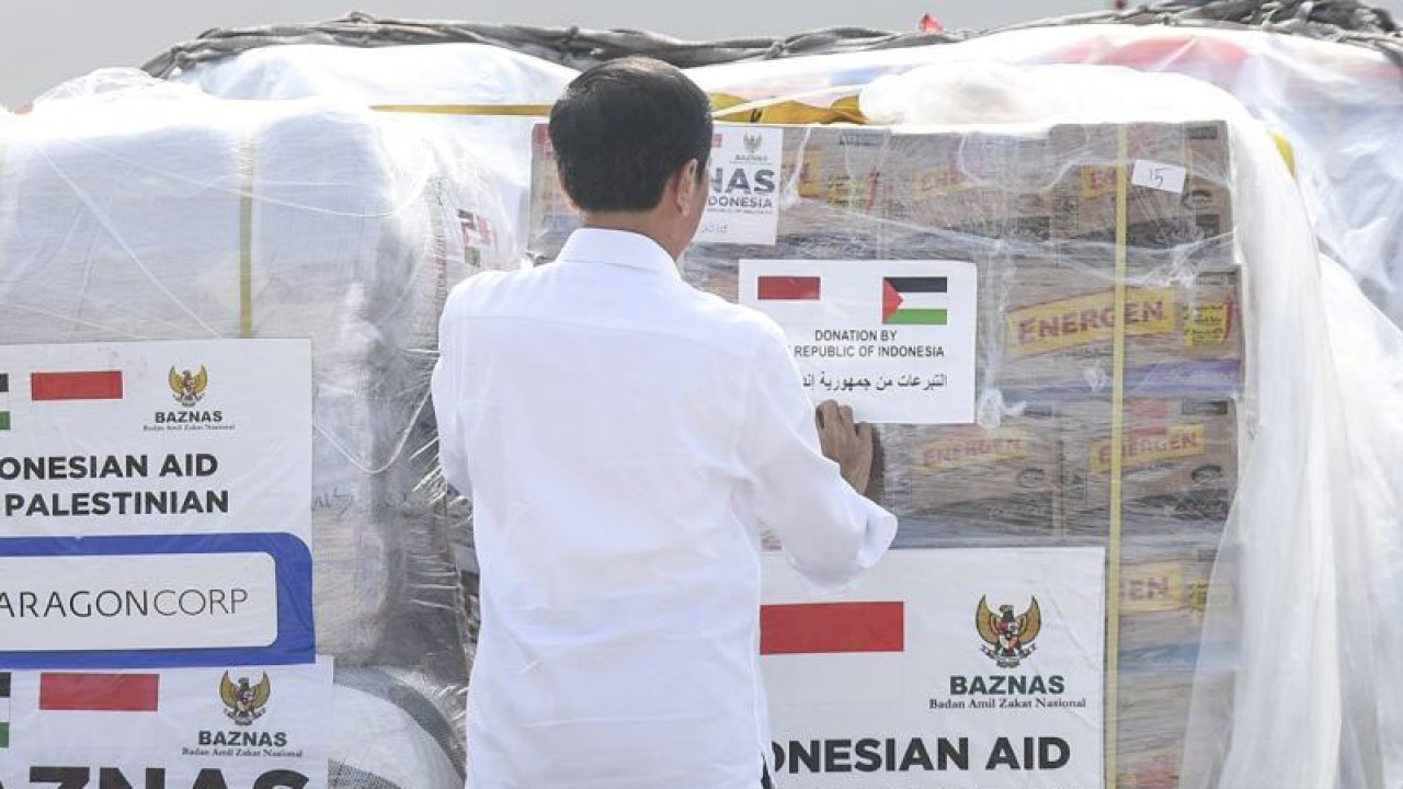 Presiden Joko Widodo menempelkan stiker saat melepas bantuan kemanuasiaan untuk Palestina di Pangkalan TNI AU Halim Perdanakusuma, Jakarta, Senin (20/11/2023). Presiden Joko Widodo melepas bantuan kemanusiaan tahap dua sebesar 21 ton berupa obat-obatan, makanan, hingga perlengkapan rumah sakit untuk masyarakat Gaza, Palestina yang bersumber dari anggaran pemerintah, perusahaan dan masyarakat. ANTARA FOTO/Hafidz Mubarak A/Spt.