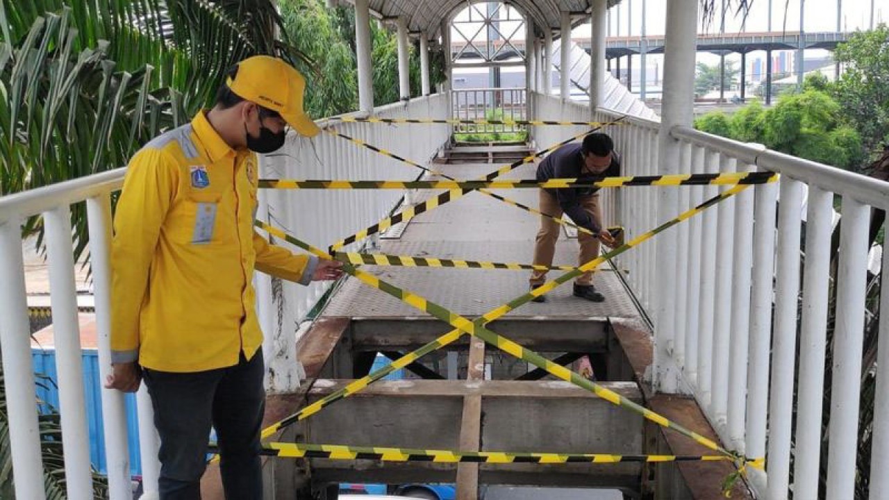 Petugas Sudin Bina Marga Jakarta Barat memasang garis pengaman pada JPO Warung Gantung di Semanan, Kalideres, Jakarta Barat, Senin (7/8/2023). ANTARA/HO-Sudin Bina Marga Jakbar/aa.
