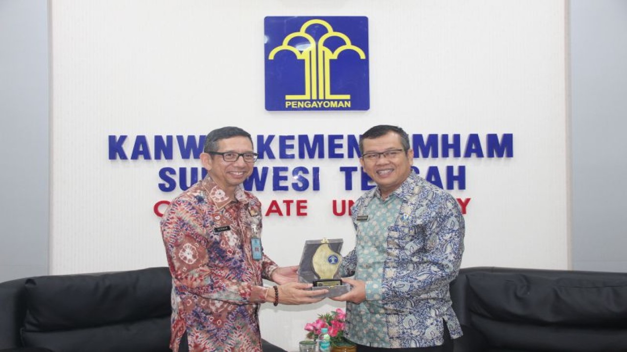 Kakanwil Kemenkumham Sulteng Hermansyah Siregar (kiri) berfoto bersama dengan Kepala BNNP Sulteng Monang Situmorang (kanan) di Kantor Wilayah Kemenkumham Sulteng, Kamis (2/1/2023). (ANTARA/HO-Humas Kemenkumham Sulteng)