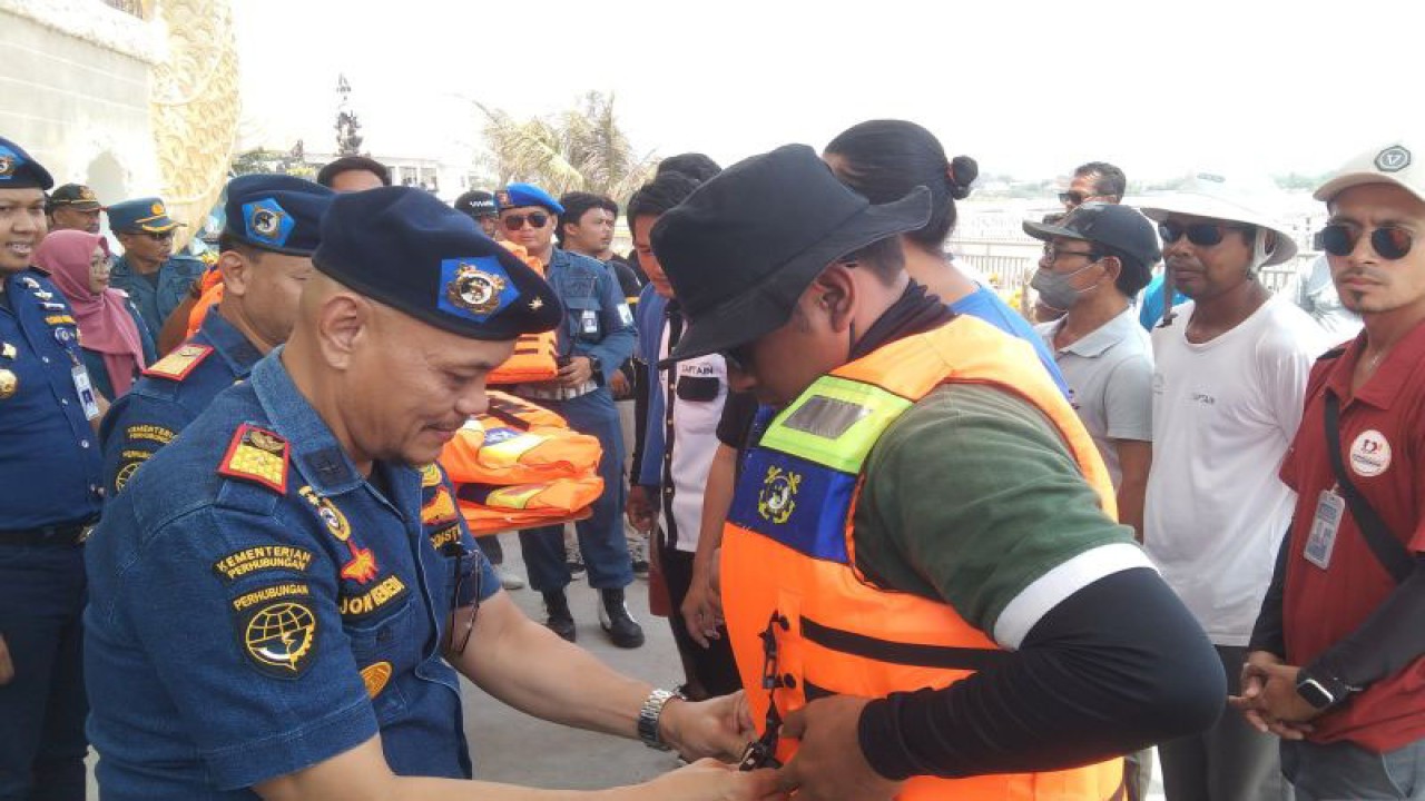 Direktur KPLP Kemenhub Jon Kenedi memasangkan jaket keselamatan kepada perwakilan awak kapal cepat di Pelabuhan Sanur, Denpasar, Bali, Kamis (9/11/2023). ANTARA/Dewa Ketut Sudiarta Wiguna