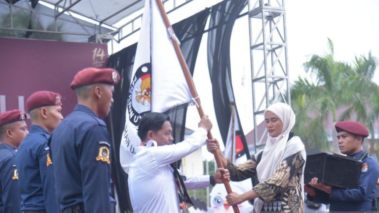 Ketua KPU Kabupaten Bekasi Ali Rido menerima bendera pataka dari Ketua KPU Kabupaten Karawang Mari Fitriani saat Kirab Pemilu 2024 tiba di Kabupaten Bekasi, Senin. (ANTARA/Pradita Kurniawan Syah).
