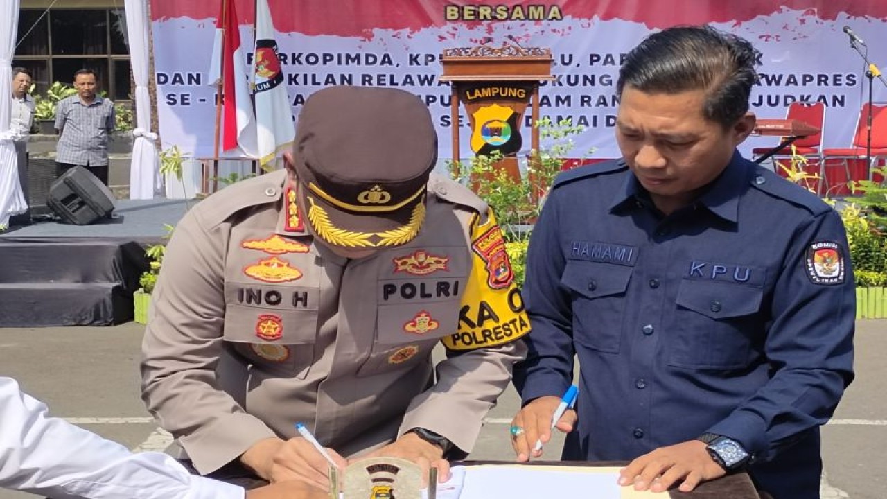 Kapolresta Bandarlaapung Kombes Pol Ino Harianto bersama anggota KPU Kota Bandarlampung Hamami saat menandatangani pakta intergritas dalam deklarasi pemilu damai. Bandarlampung, Selasa, (14/11/2024). (ANTARA/Dian Hadiyatna)