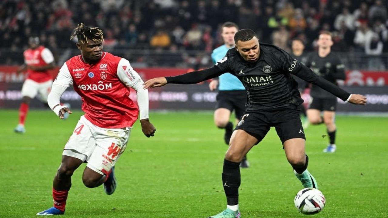 Bek Reims Emmanuel Agbadou (kiri) mencoba merebut bola dari penguasaan penyerang PSG Kylian Mbappe (kanan), pada pertandingan Liga Prancis yang dimainkan di Stade Auguste-Delaune, Reims, Sabtu (11/11/2023). (ANTARA/AFP/FRANCOIS NASCIMBENI)