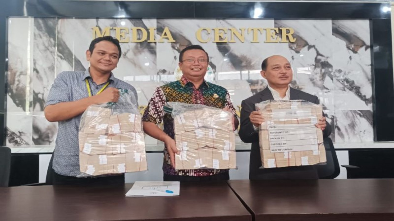 Kajari Surabaya Joko Budi Darmawan disaksikan perwakilan dari LPSK (kanan) dan bank (kiri) mengembalikan barang bukti yang dirampas dari aset perusahaan robot trading Viral Blast Global untuk dikembalikan kepada para korban secara proporsional di Surabaya, Jumat (17/11/2023). ANTARA/Hanif Nashrullah.