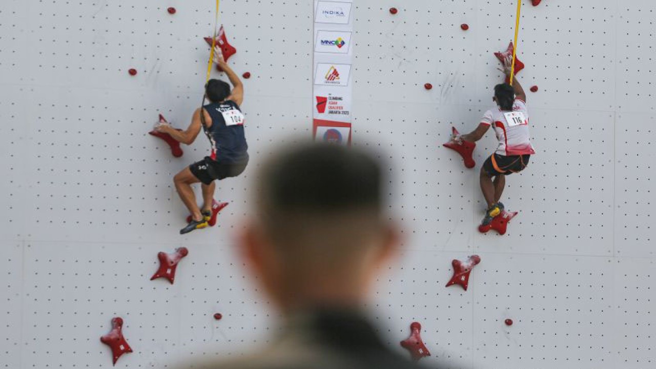Atlet panjat tebing Indonesia Rahmad Adi Mulyono (kanan) beradu kecepatan dengan atlet Korea Selatan Seungbeom Lee (kiri) saat babak kualifikasi kategori Speed IFSC Asian Qualifier Jakarta 2023 di Arena Panjat Tebing GBK, Jakarta, Minggu (12/11/2023). ANTARA FOTO/Asprilla Dwi Adha/aww
