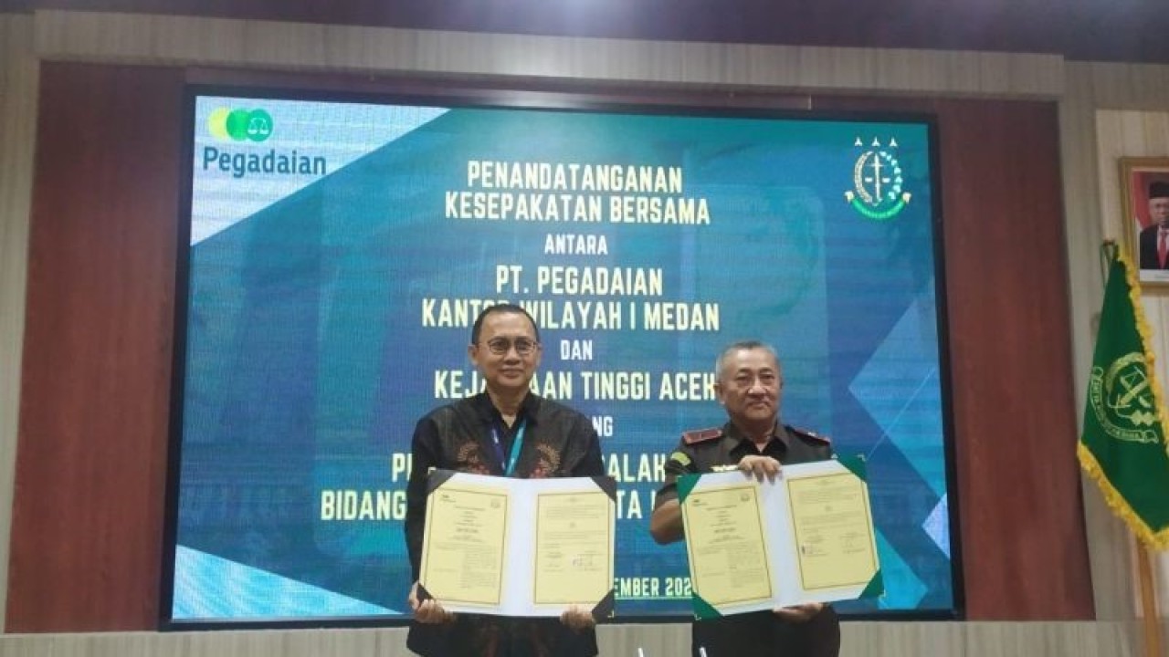 Pimpinan PT Pegadaian I Medan Arief Rinardi Sunardi (kiri) bersama Kajati Aceh Joko Purwanto (kanan) saat melakukan penandatanganan nota kesepahaman (MoU) tentang penanganan masalah hukum bidang perdata dan tata usaha negara, di Banda Aceh, Rabu (15/11/2023). ANTARA/Rahmat Fajri.