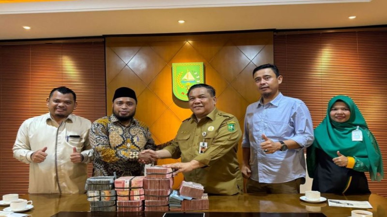 Sekretaris Daerah Provinsi Riau SF Hariyanto menyerahkan sumbangan dana untuk rakyat Palestina kepada Ketua BAZNAS Riau Masriadi Hasan di ruang kerja Kantor Gubernur Riau di Kota Pekanbaru, Selasa (14/11/2023). (ANTARA/HO-Humas Pemprov Riau)