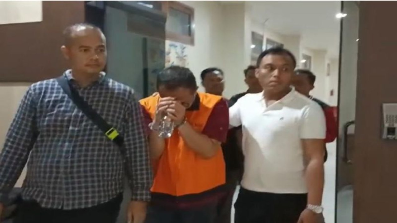 Kepala Seksi Pemeriksaan I Kantor Imigrasi Kelas I Khusus TPI Ngurah Rai Haryo Seto (rompi oranye) menuju mobil tahanan untuk dibawa ke Rumah Tahanan Kelas II A Kerobokan, Kabupaten Badung, Bali, Rabu (15/11/2023). (ANTARA/HO-Kasipenkum Kejati Bali)