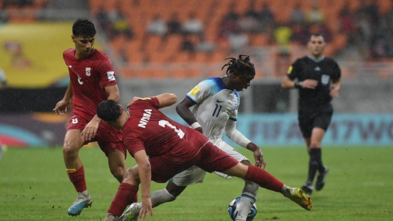 Pesepak bola Timnas Inggris Joel Ndala (kanan) berebut bola dengan pesepak bola Timnas Iran Nima Andarz (tengah) saat bertanding dalam laga penyisihan Grup C Piala Dunia U-17 di Jakarta International Stadium, Jakarta, Selasa (14/11/2023). ANTARA FOTO/Akbar Nugroho Gumay/YU