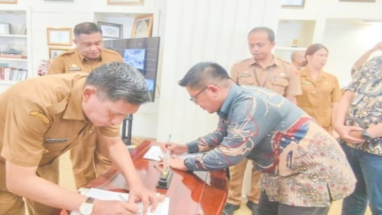 Penjabat Wali Kota Ambon, Bodewin Wattimena (kiri) bersama Penjabat Area Head Maluku PT Bank Mandiri, Azizi Rahim (kanan) melakukan penandatanganan kerjasama tentang pengembangan layanan perbankan bagi kepentingan Publik di Kota Ambon. ANTARA/ Ho- Diskominfo sandi Ambon.