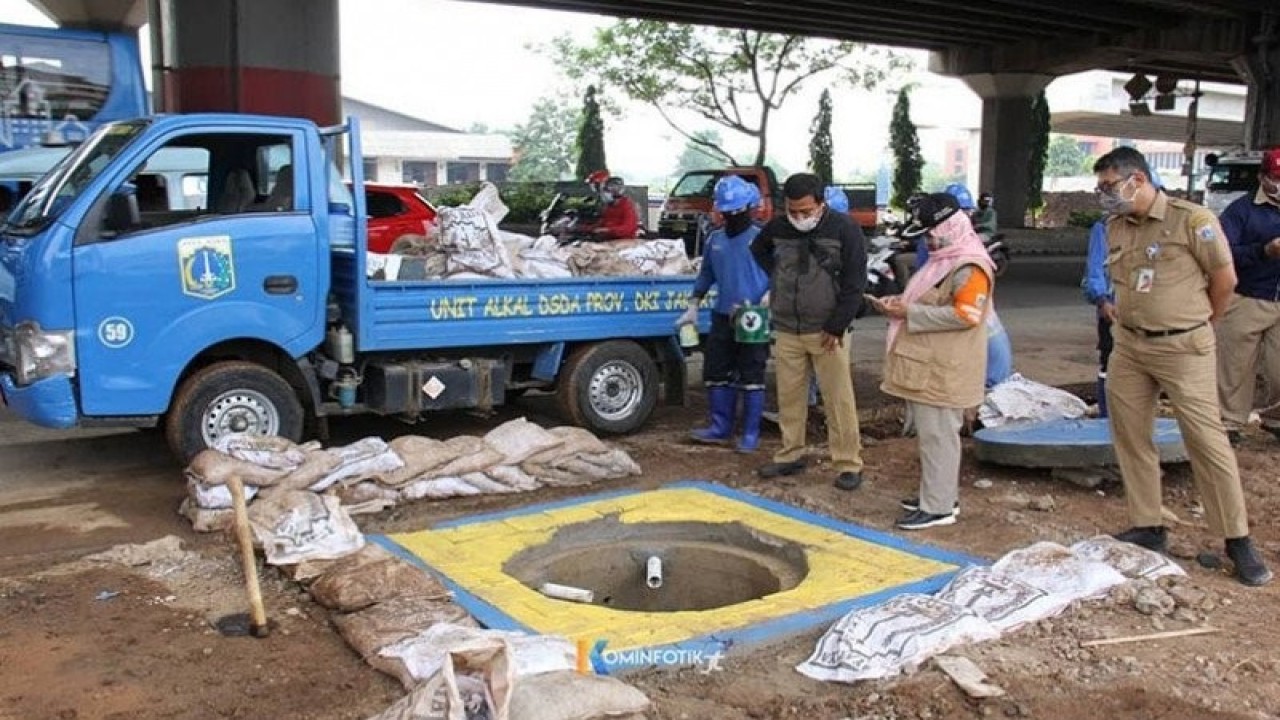 Petugas Suku Dinas Sumber Daya Alam Jakarta Timur mengecat sejumlah bagian sumur resapan yang dibuat untuk mengantisipasi genangan air di lintasan Jalan DI Panjaitan, Rabu (23/9/2020). ANTARA/HO-Kominfotik Jaktim/aa. (Handout Kominfotik Jaktim)