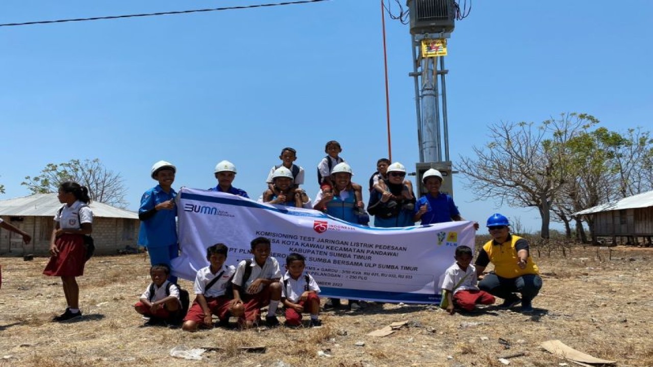 Petugas PLN bersama pelajar di Sumba berpose bersama di bawah gardu listrik. ANTARA/Ho-PLN NTT