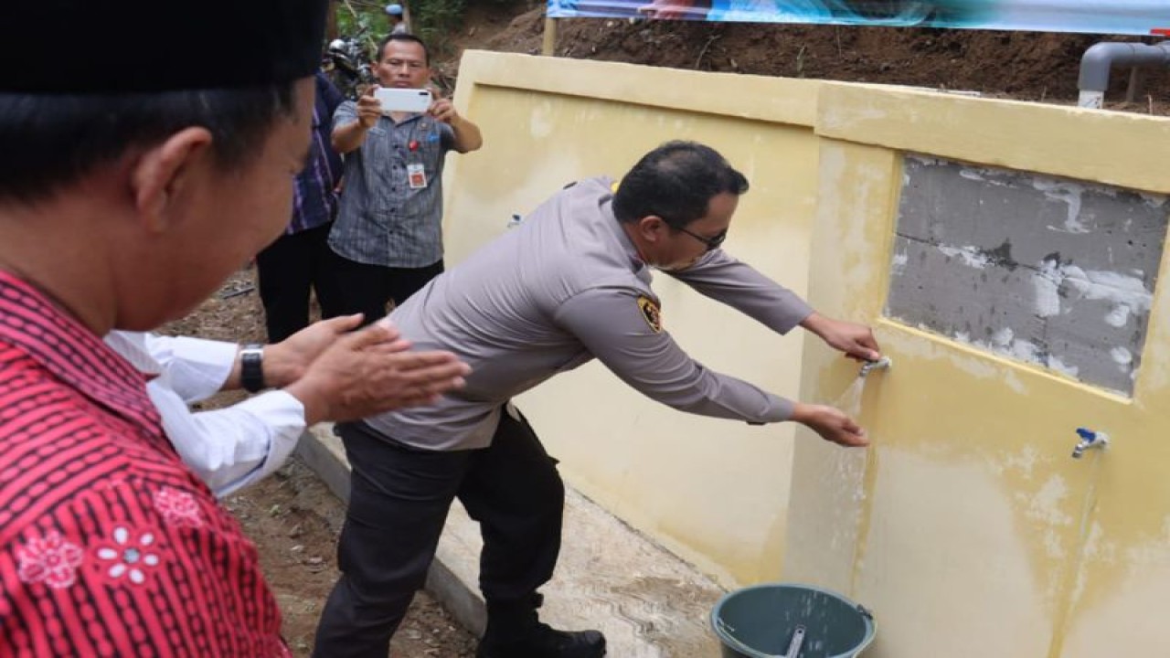 Kapolres Purbalingga AKBP Hendra Irawan saat membuka keran air usai menyerahkan bantuan sumur bor untuk warga terdampak kekeringan di Desa Kaliori, Kecamatan Karanganyar, Kabupaten Purbalingga, Jateng, Selasa (7/11/2023). ANTARA/HO-Polres Purbalingga.