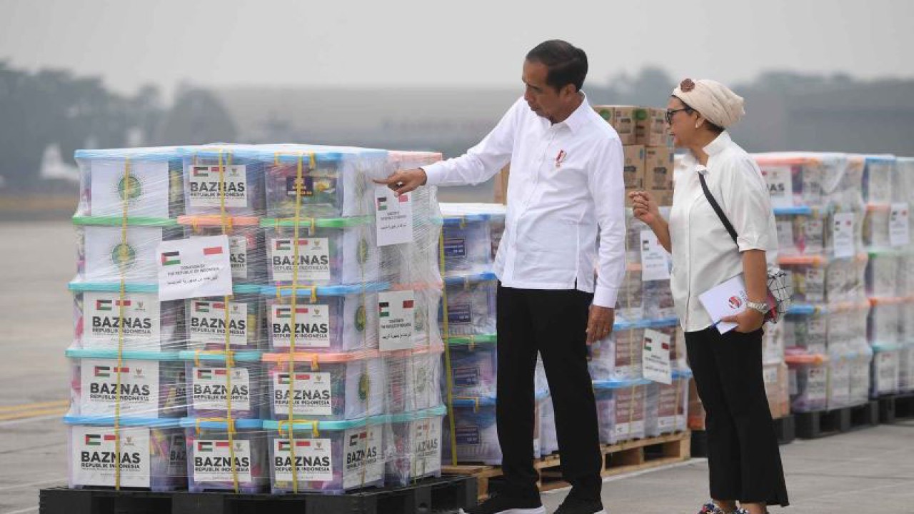 Presiden Joko Widodo (kiri) meninjau bantuan untuk Palestina didampingi Menlu Retno Marsudi (kanan) di Pangkalan Udara TNI AU Halim Perdana Kusuma, Jakarta, Sabtu (4/11/2023). Presiden melepas bantuan tahap pertama yang akan diterbangkan dengan tiga pesawat berisi 51,5 ton bantuan berupa bahan makanan, alat medis, selimut, tenda dan barang-barang logistik lainnya yang telah disesuaikan dengan kebutuhan di Gaza. ANTARA FOTO/Akbar Nugroho Gumay/nym.