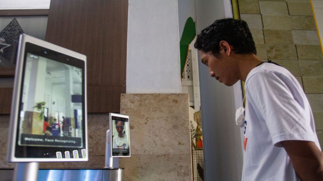 Calon penumpang melakukan scan wajah di Stasiun Yogyakarta, Senin (3/4/2023). PT Kereta Api Indonesia melakukan peningkatan layanan dengan menerapkan teknologi "Face Recognition Boarding Gate" untuk mengurai antrian para pemudik yang menggunakan kereta api. ANTARA FOTO/Hendra Nurdiyansyah.