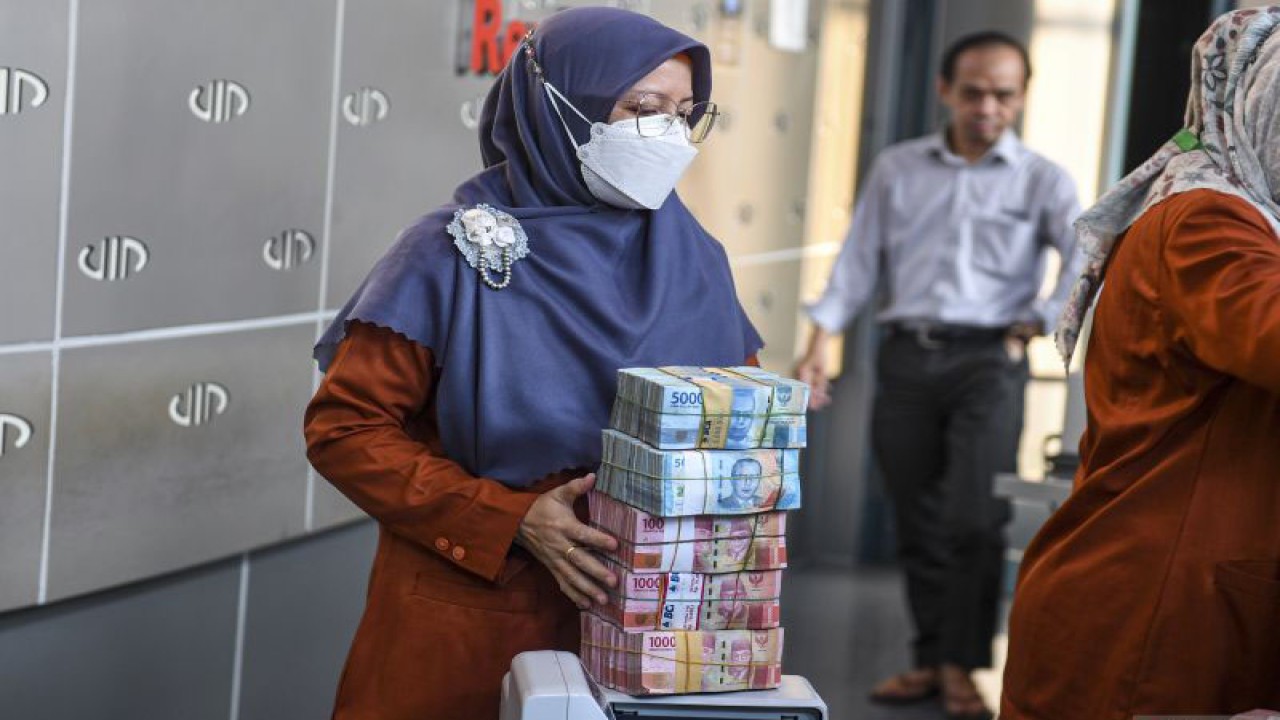 Petugas membawa uang pecahan rupiah di gerai penukaran mata uang asing VIP (Valuta Inti Prima) Money Changer, Jakarta, Senin (20/11/2023). ANTARA FOTO/Muhammad Adimaja/YU (ANTARA FOTO/MUHAMMAD ADIMAJA)