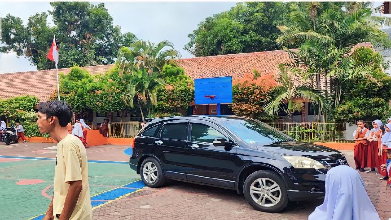 Sebuah mobil yang ditumpangi oleh Kepala Sekolah SDN 10 Malaka Jaya, Junawati bersama guru honorer berinisial A yang akan berangkat ke Inspektorat DKI Jakarta di SDN 10 Malaka Jaya, Kecamatan Duren Sawit, Jakarta Timur, Selasa (28/11/2023). ANTARA/Syaiful Hakim