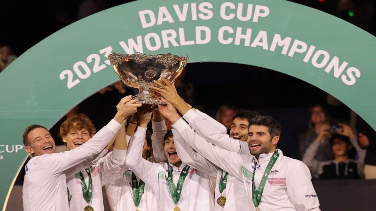 Anggota tim Italia mengangkat trofi setelah mereka menjadi juara Piala Davis di Martin Carpena Sporthall, Malaga, Spanyol, Minggu (26/11/2023). (ANTARA/AFP/LLUIS GENE)