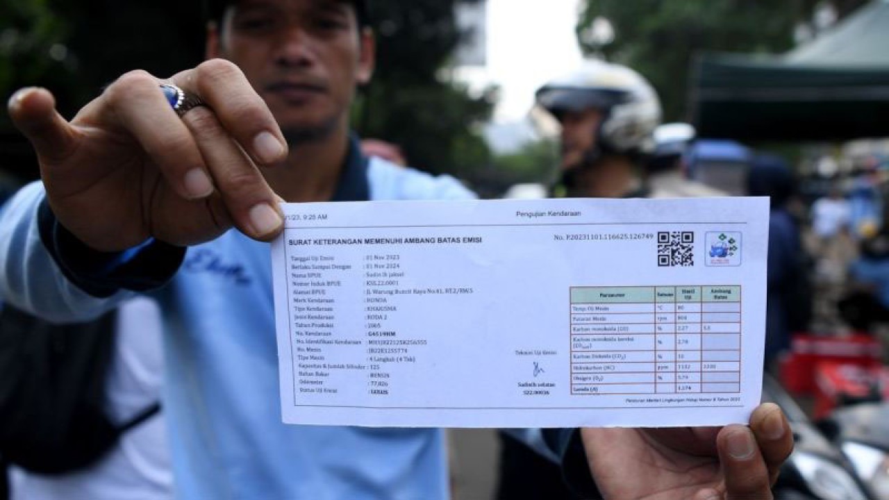 Petugas Suku Dinas Lingkungan Hidup Jakarta Selatan menunjukkan surat lolos uji emisi kendaraan bermotor saat razia di Lebak Bulus, Jakarta Selatan, Rabu (1/11/2023). Pemerintah Provinsi DKI Jakarta dan Polda Metro Jaya kembali memberlakukan tilang terhadap kendaraan yang tidak lolos uji emisi mulai 1 November 2023 dengan denda Rp250 ribu untuk kendaraan roda dua dan Rp500 ribu untuk kendaraan roda empat. ANTARA FOTO/Sigid Kurniawan/tom.