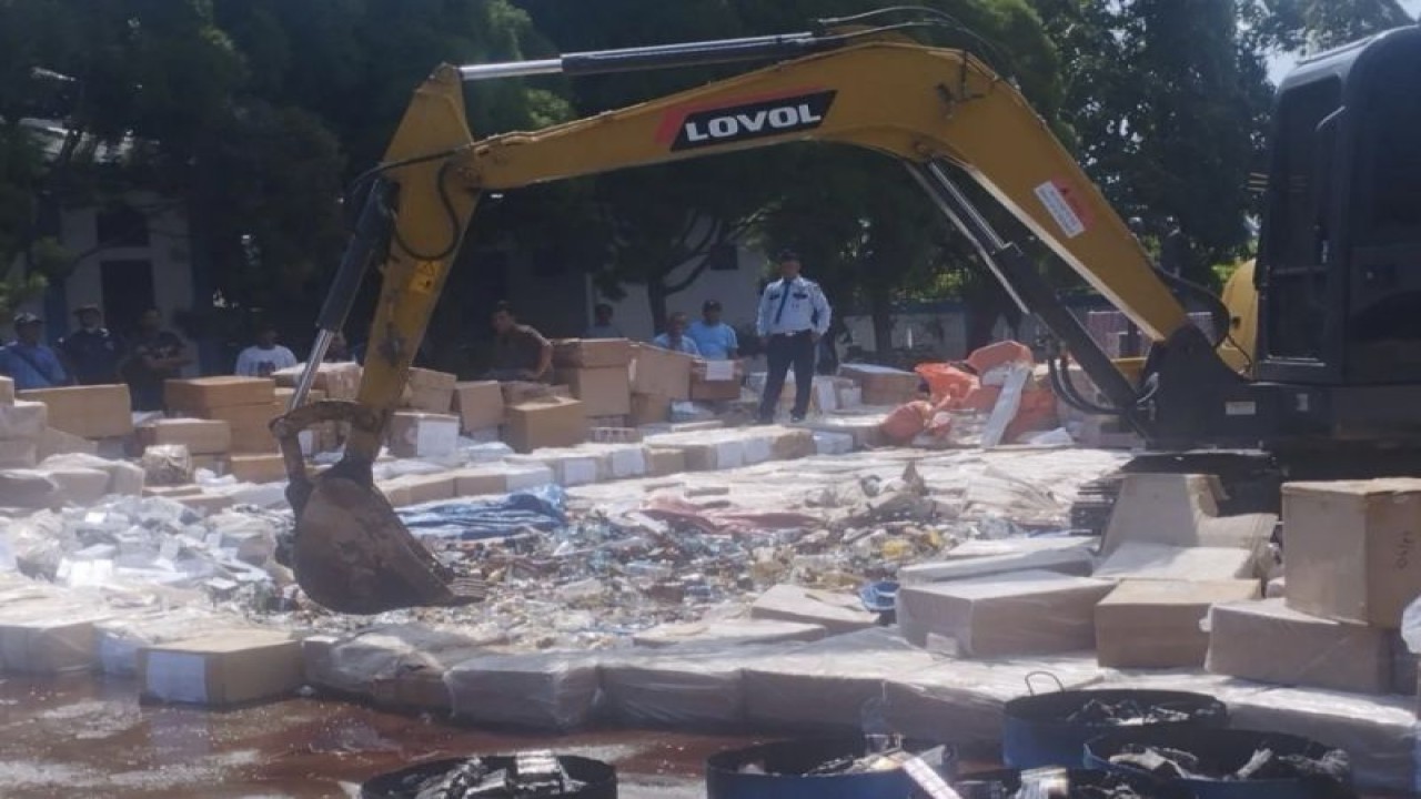 Alat berat melindasi ribuan botol minuman beralkohol yang merupakan barang hasil tegahan Bea Cukai di Perairan Riau.ANTARA/Abdul Razak