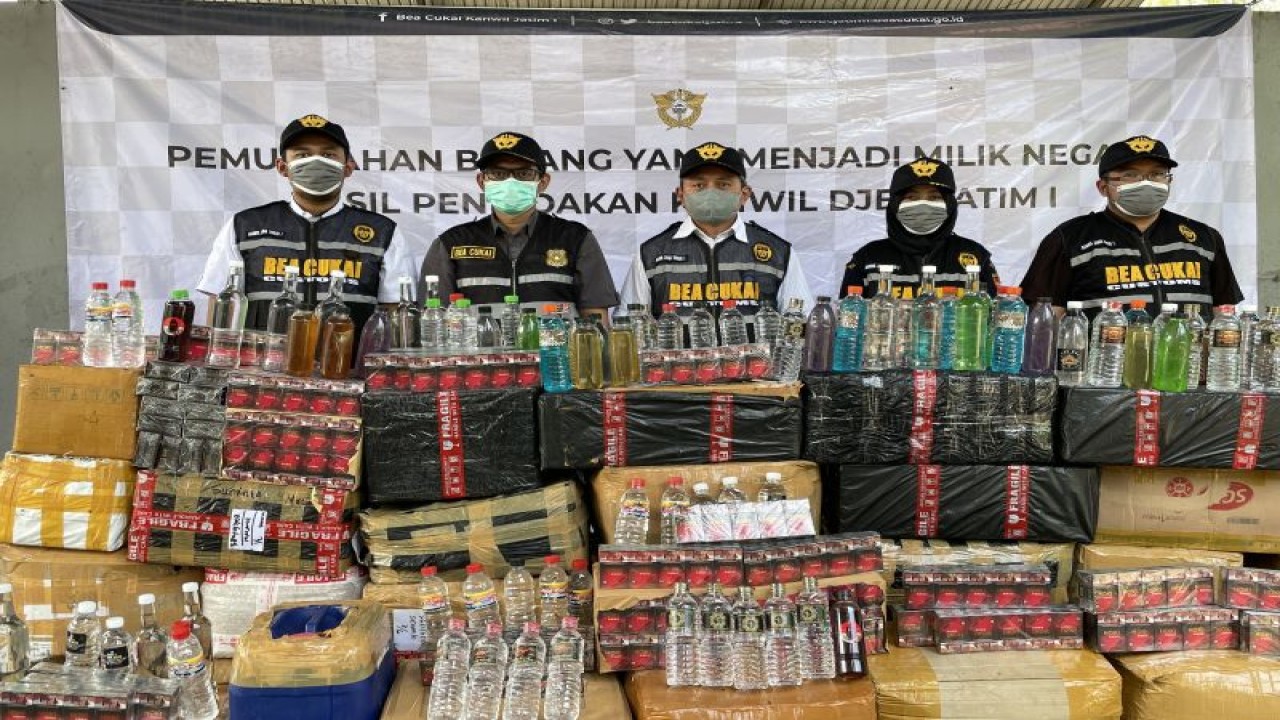 Petugas menunjukkan barang bukti minuman keras ilegal dan rokok ilegal. ANTARA/HO-Bea Cukai Jatim