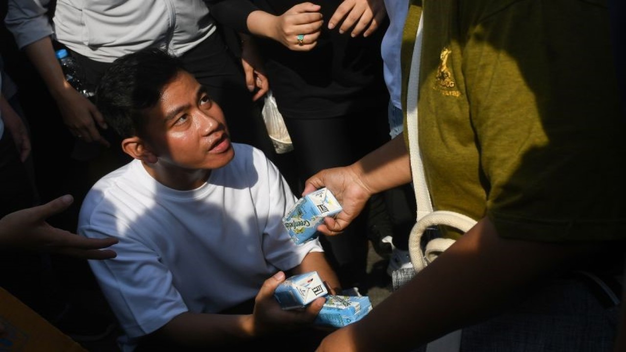 Cawapres nomor urut 2 Gibran Rakabuming Raka membagikan susu kemasan ke warga di area hari bebas kendaraan bermotor (HBKB) Jalan MH Thamrin, Jakarta, Minggu (3/12/2023). Dalam kesempatan tersebut Gibran menyapa warga yang sedang berolah raga saat HBKB atau 'car free day' (CFD) dan membagikan susu ke anak-anak. ANTARA FOTO/Aditya Pradana Putra/rwa. (ADITYA PRADANA PUTRA/ADITYA PRADANA PUTRA)