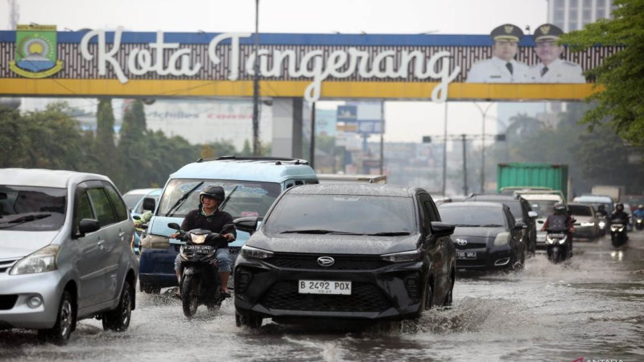 Ilustrasi: Pengendara motor dan mobil melintasi genangan air yang merendam jalan raya Serpong saat hujan mengguyur Kota Tangerang dan sekitarnya di Serpong, Tangerang Selatan, Banten, Selasa (24/10/2023). . ANTARA FOTO/Muhammad Iqbal/aww. (ANTARA FOTO/MUHAMMAD IQBAL)