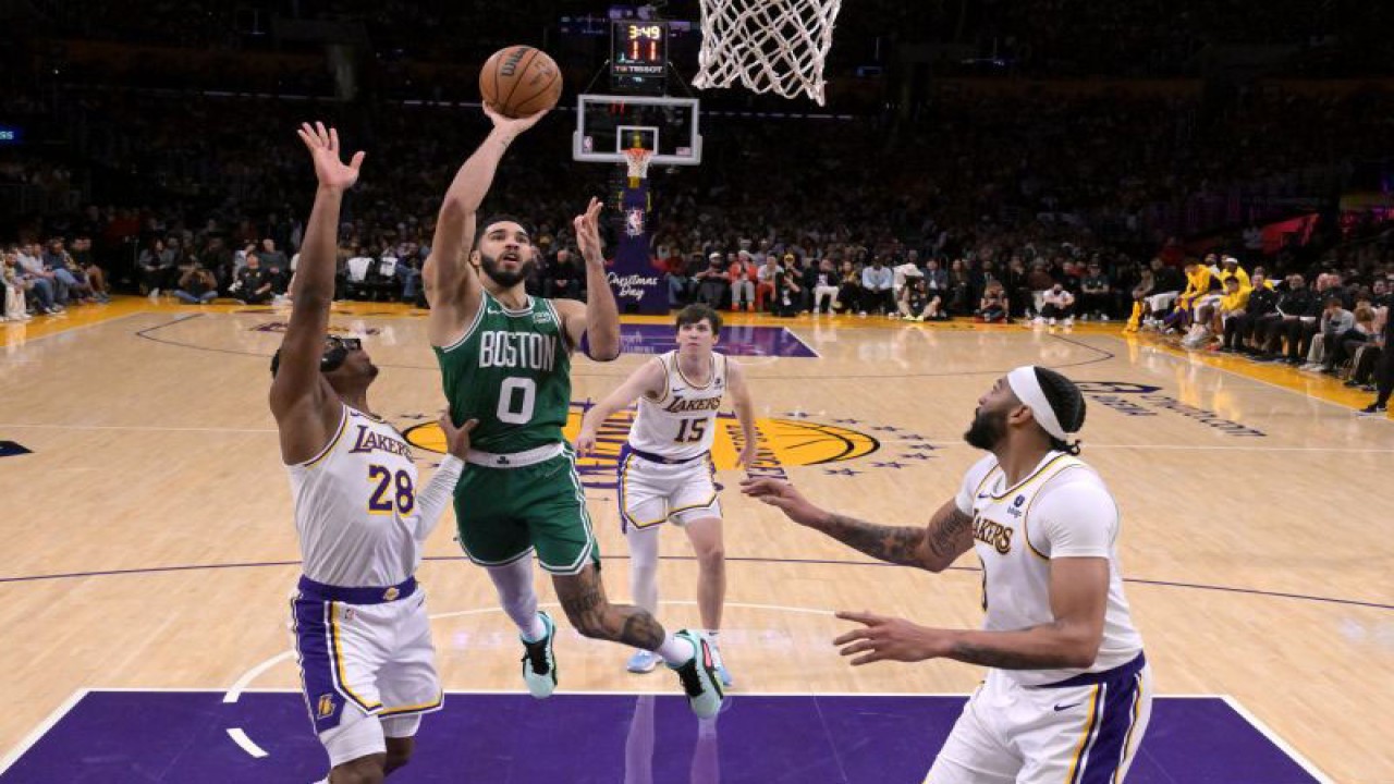 Pemain Boston Celtics Jayson Tatum (kedua dari kiri) melakukan drive ke arah ring basket dengan dikawal dua pemain Los Angeles Lakers Rui Hachimura (kiri) dan Anthony Davis (kanan) pada pertandingan NBA yang berlansung di Crypto.com Arena, Los Angeles, Senin (25/12/2023). (ANTARA/AFP/JAYNE KAMIN-ONCEA)