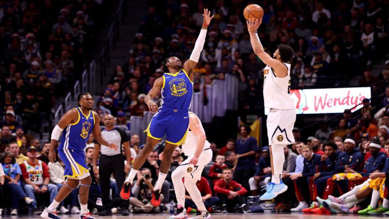 Pemain Denver Nuggets Jamal Murray (kanan) melepaskan tembakan sambil coba dihalau pemain Golden State Warriors Jonathan Kuminga, pada pertandingan NBA yang dimainkan di Ball Arena, Denver, Senin (25/12/2-23). (ANTARA/AFP/JAMIE SCHWABEROW)