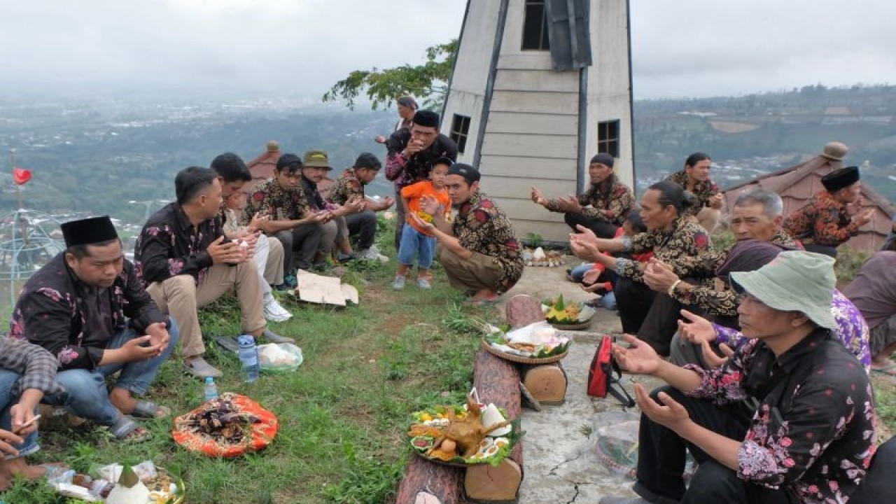 Wisatawan bersama warga berdoa bersama saat tradisi Merti Desa Petarangan di puncak bukit Botorono kawasan lereng Gunung Sumbing, Petarangan, Kledung, Temanggung, Jateng, Rabu (29/11/2023). ANTARA FOTO/Anis Efizudin/Spt. (ANTARA FOTO/ANIS EFIZUDIN)