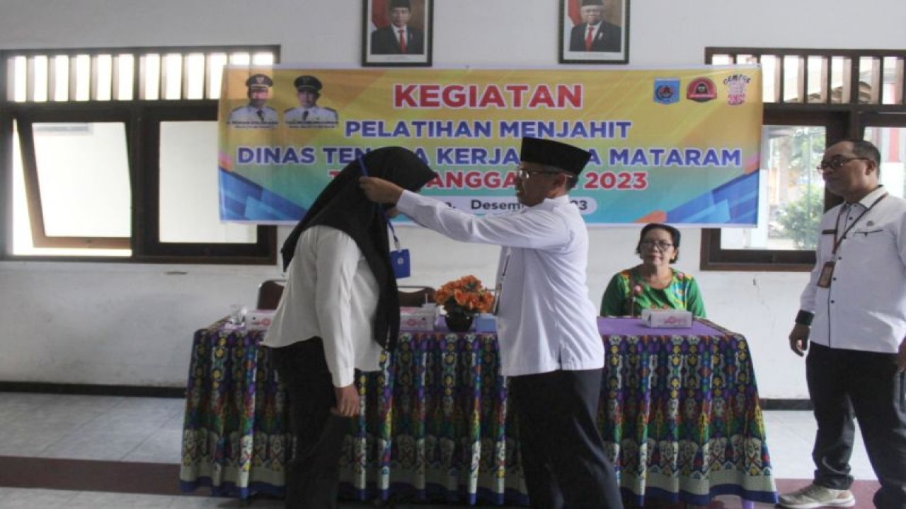 Kepala Dinas Tenaga Kerja (Disnaker) Kota Mataram H Rudi Surywan (kanan) secara simbols mengalungkan tanda peserta pelatihan menjahit kepada 40 warga di Kota Mataram, Provinsi Nusa Tenggara Barat, yang masuk kategori kemiskinan ekstrem, Rabu (6/12-2023). (ANTARA/Disnaker Mataram)