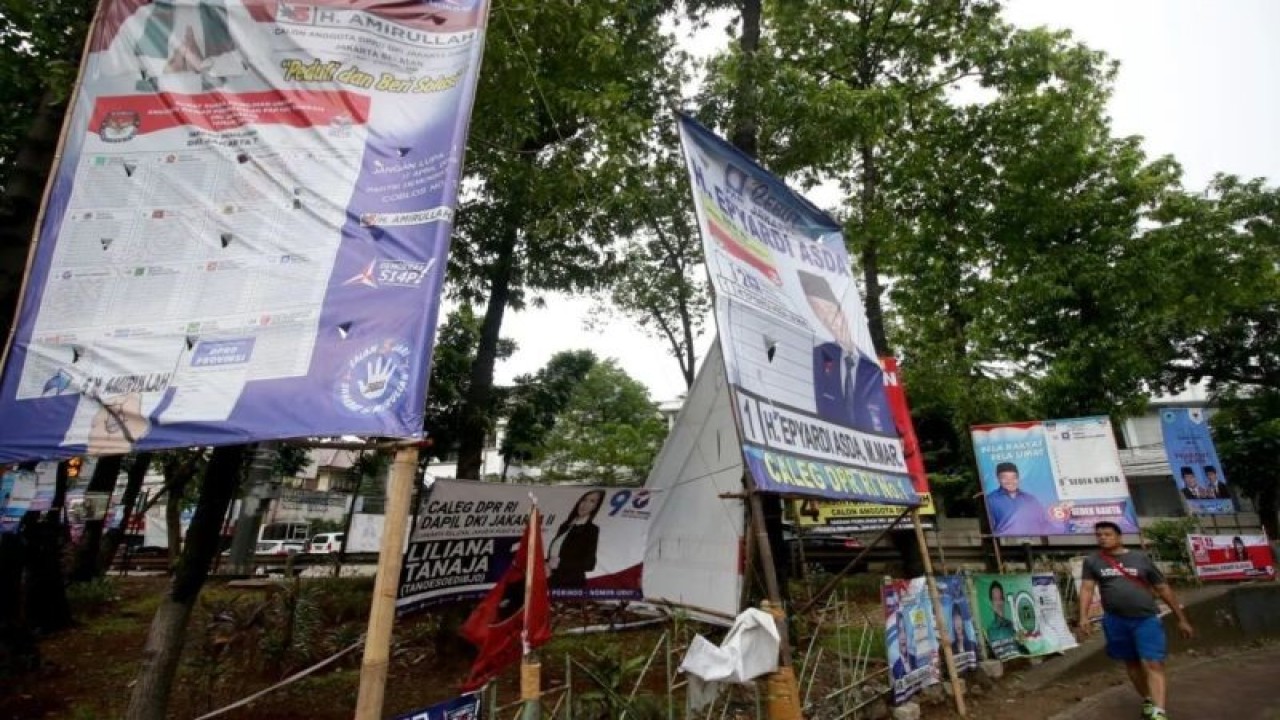 Arsip Foto - Pejalan kaki melintas di depan Alat Peraga Kampanye (APK) Pemilu 2019 di kawasan Kebayoran, Jakarta, Senin (25/3/2019). Keberadaan Alat Peraga Kampanye yang terpasang di pinggir jalan tersebut berdampak pada rusaknya pemandangan dan keindahan ruang publik. ANTARA FOTO/Rivan Awal Lingga/foc.