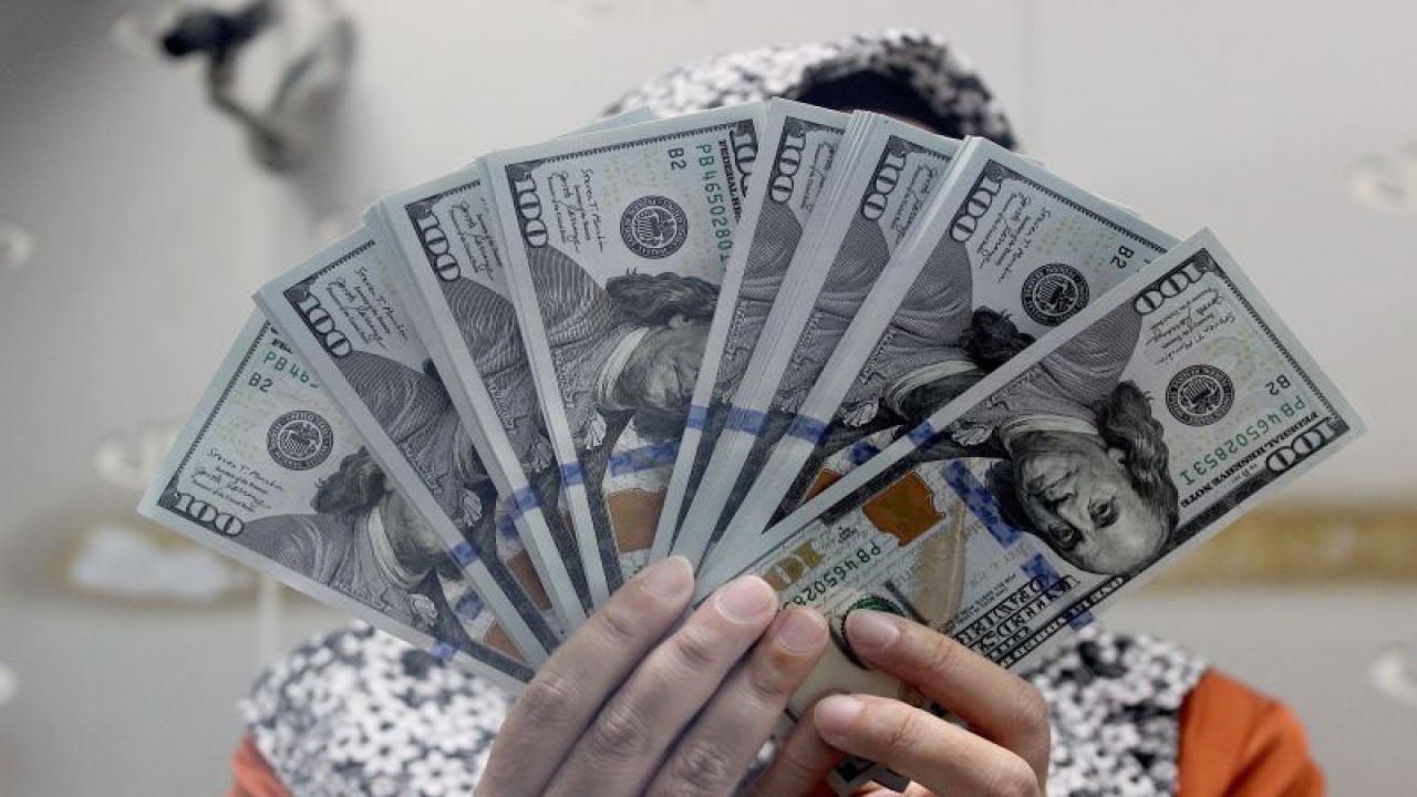 Arsip - Seorang petugas menunjukkan lembaran uang dolar Amerika Serikat di Jakarta, Senin (27/11/2023). .ANTARA FOTO/Putu Indah Savitri/wpa/rwa.