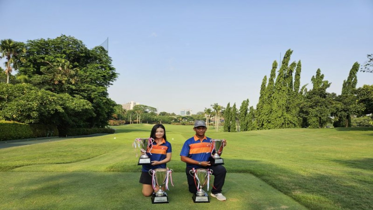 Elaine Widjaja (kiri) dan Rayhan Abdul Latif (kanan) berfoto dengan trofi-trofi yang mereka menangi di ajang Medco Foundation powered by Metaforsa Pondok Indah International Junior Golf Championship 2023, di Pondok Indah Golf Course, Jakarta, Kamis (14/12/2023). (ANTARA/RAUF ADIPATI)