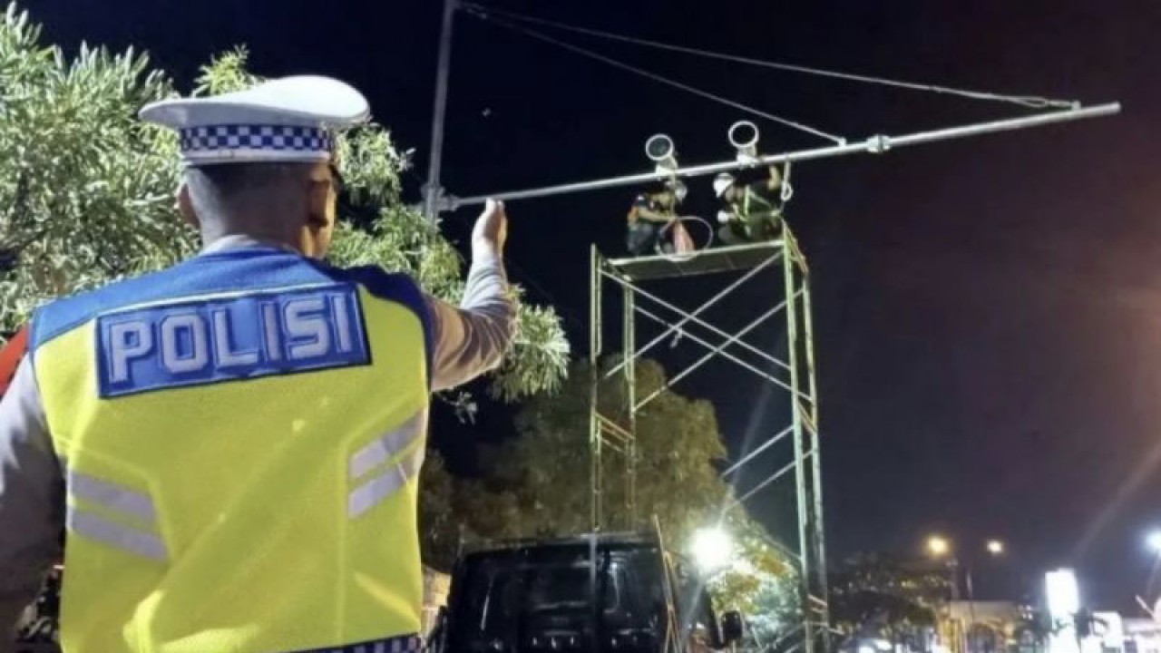 Anggota Polri menunjukkan kamera ETLE yang merekam kendaraan dan memonitor yang melanggar lalu lintas. (ANTARA/ Fauzi Fadilah)ETLE