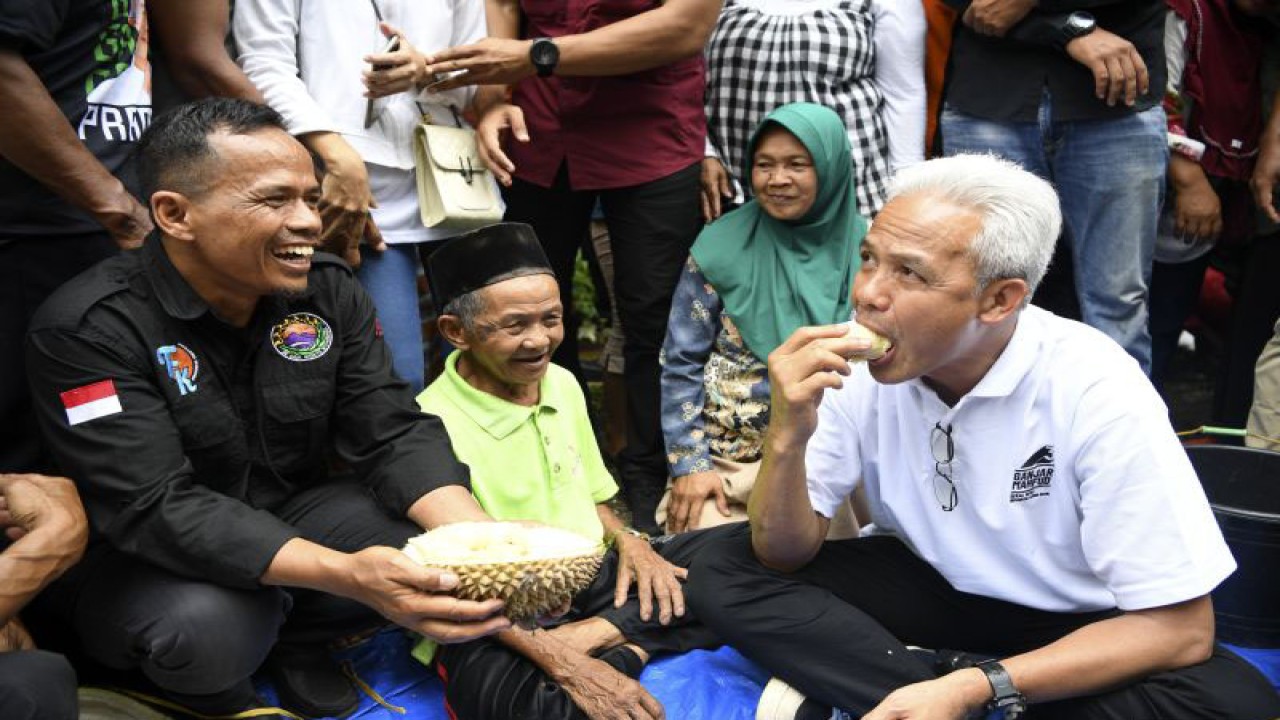 Capres nomor urut 3 Ganjar Pranowo (kanan) saat mencicipi buah durian di Desa Wilayu, Selomerto, Kabupaten Wonosobo, Jawa Tengah, Senin (18/12/2023). (ANTARA FOTO/M Risyal Hidayat/tom)