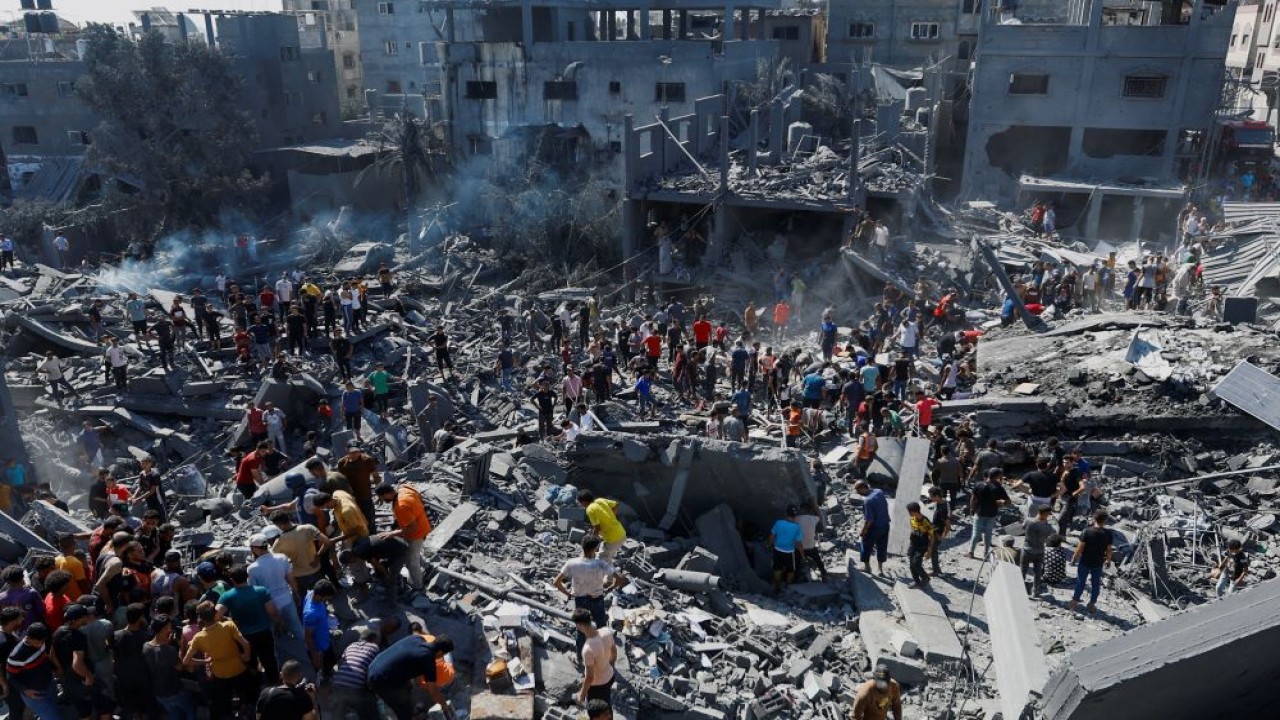 Warga Palestina mencari korban di lokasi serangan Israel di rumah-rumah, saat konflik antara Israel dan kelompok Islam Palestina Hamas berlanjut, di Khan Younis di selatan Jalur Gaza, pada 26 Oktober 2023. (Ibraheem Abu Mustafa/Reuters)