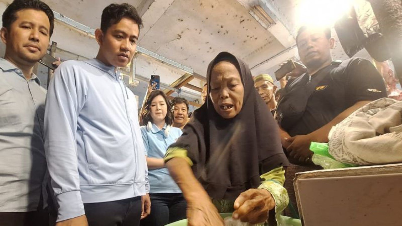 Calon wakil presiden nomor urut 2, Gibran Rakabuming Raka (kedua kiri), bersama juru bicara Tim Kampanye Nasional (TKN) Prabowo-Gibran, Emil Dardak (kiri) menemui para pedagang di Pasar Pandan Sari, Kota Balikpapan, Kalimantan Timur, Sabtu (16/12). Selain berbincang, Gibran juga membeli sejumlah barang seperti kacang dan palawija lain di Pasar Pandan Sari. (ANTARA Kaltim/Januar)