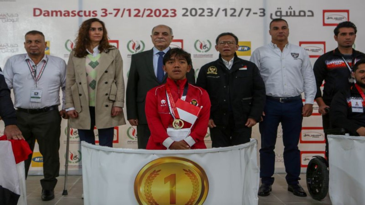 Atleet Para renang Indonesia Muhammad Gery Pahker menerima medali emas pada Wounded Homeland Games 2023 di Damaskus, Suriah, Senin (4/12/2023). (ANTARA/HO/NPC Indonesia)
