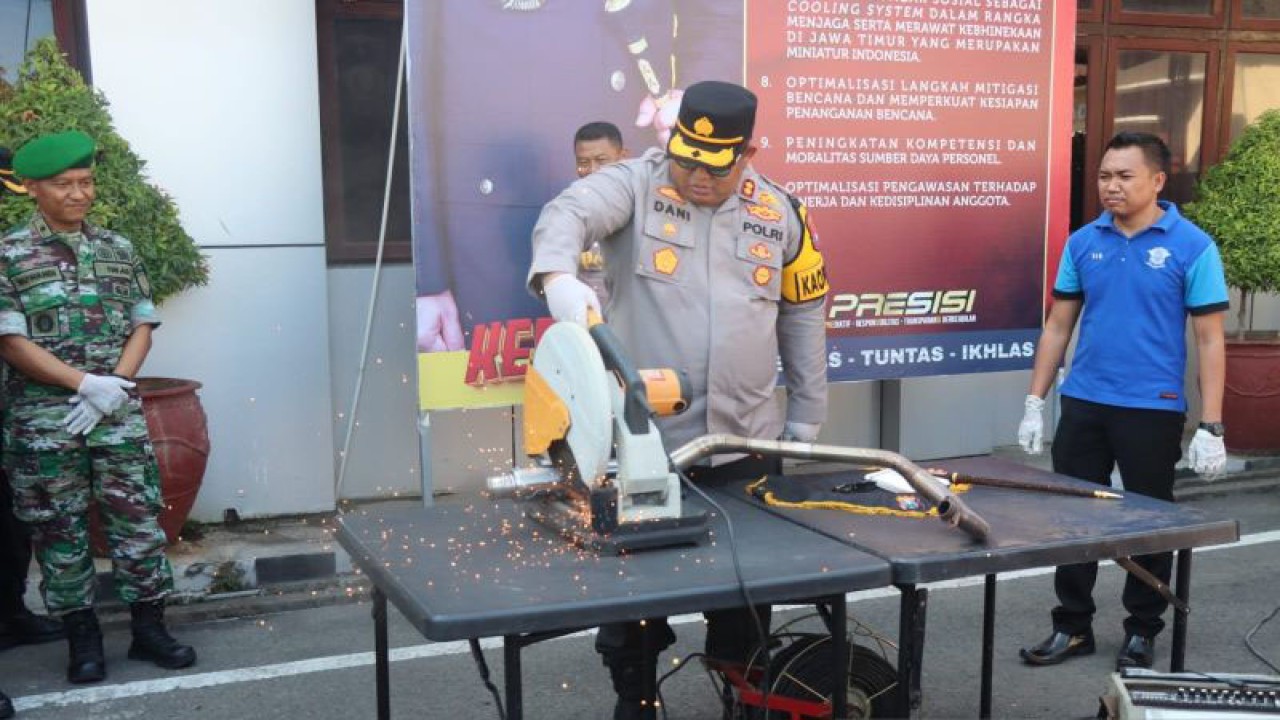 Kapolres Pamekasan AKBP Jazuli Dani Iriawan memotong knalpot brong hasil operasi petugas menjelang pergantian Malam Tahun Baru 2024 di halaman Mapolres Pamekasan, Jumat (29/12/2023). (ANTARA/ HO-Polres Pamekasan)