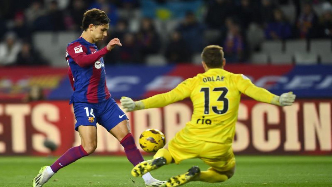 Penyerang Barcelona Joao Felix (kiri) mencetak gol ke gawang Atletico Madrid, pada pertandingan Liga Spanyol yang dimainkan di Stadion Olympic Lluis Companys, Barcelona, Minggu (3/12/2023). (ANTARA/AFP/PAU BARRENA)