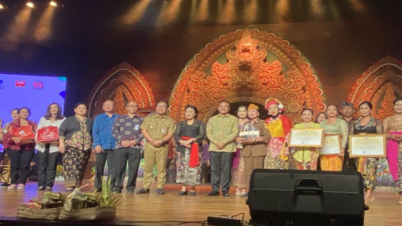 Menteri PPPA I Gusti Ayu Bintang Darmawati saat membagikan bantuan sosial dalam rangkaian peringatan Hari Ibu di Bali, Denpasar, Senin (18/12/2023). ANTARA/Ni Putu Putri Muliantari