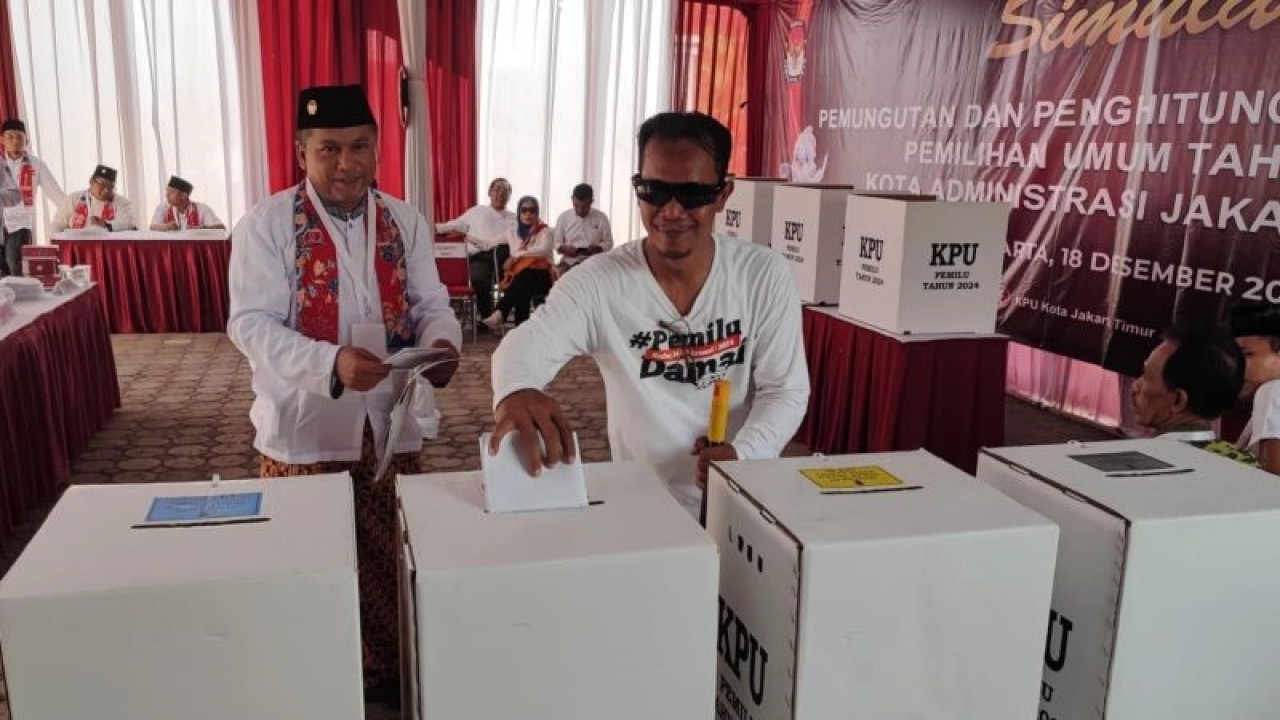 Petugas Kelompok Penyelenggara Pemungutan Suara (KPPS) tengah mendampingi salah satu warga tuna netra saat memasukan surat suara ke kotak suara dalam simulasi pemungutan dan penghitungan suara Pemilu 2024 di Kantor KPU Jakarta Timur, Pulogadung, Senin (18/12/2023). ANTARA/Syaiful Hakim